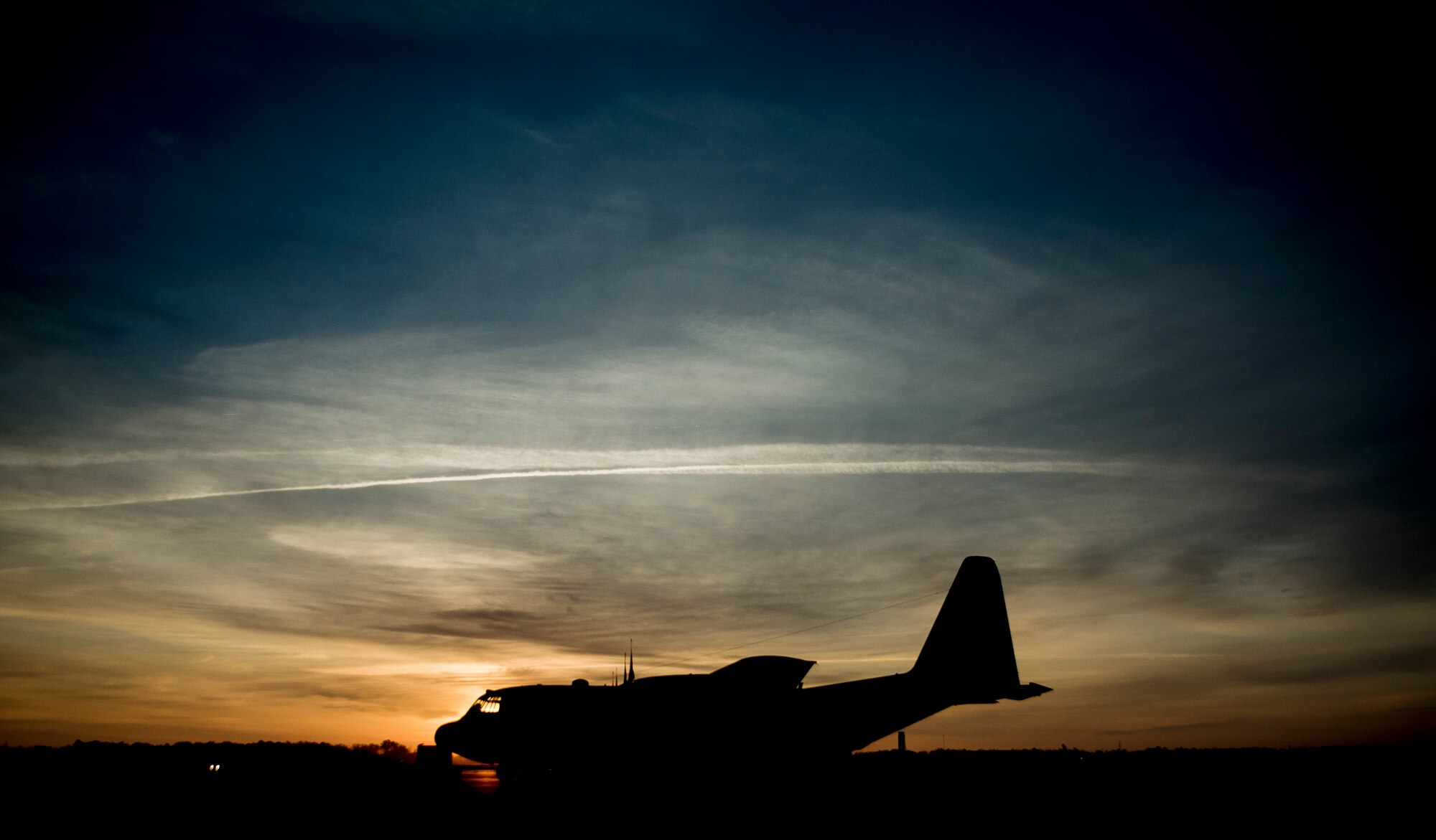 The sun rises above a C-130 Hercules March 27, 2014, at Joint Base Charleston, S.C. The aircraft is capable of operating from rough, dirt strips and is the prime transport for airdropping troops and equipment into hostile areas. The C-130 operates throughout the U.S. Air Force, serving with Air Mobility Command, Air Force Special Operations Command, Air Combat Command, U.S. Air Forces in Europe, Pacific Air Forces, Air National Guard and the Air Force Reserve Command, fulfilling a wide range of operational missions in both peace and war situations. (U.S. Air Force photo/Senior Airman Dennis Sloan)