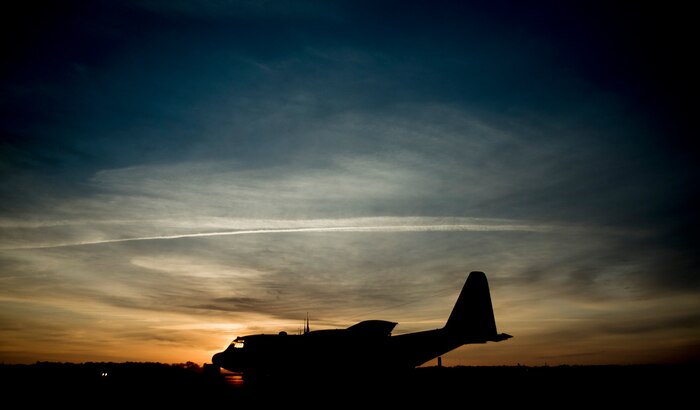 The sun rises above a C-130 Hercules March 27, 2014, at Joint Base Charleston, S.C. The aircraft is capable of operating from rough, dirt strips and is the prime transport for airdropping troops and equipment into hostile areas. The C-130 operates throughout the U.S. Air Force, serving with Air Mobility Command, Air Force Special Operations Command, Air Combat Command, U.S. Air Forces in Europe, Pacific Air Forces, Air National Guard and the Air Force Reserve Command, fulfilling a wide range of operational missions in both peace and war situations. (U.S. Air Force photo/Senior Airman Dennis Sloan)