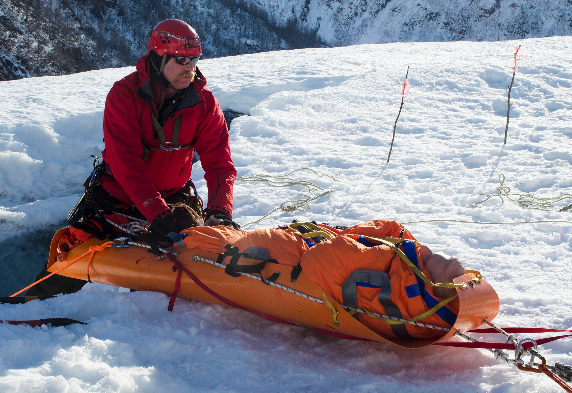 Josh Larsen, a lieutenant with the Valdez Fire Department guides a simulated casualty on a litter during a glacier rescue here, during Alaska Shield 14 here, March 30, 2014. Alaska Shield 14 is an exercise that involves federal, state, local, and military agencies, designed to test response and coordination efforts during a disaster and is modeled after the 1964 earthquake and subsequent tsunami that devastated much of South Central Alaska including the city of Valdez. (U.S. Army photo by Spc. True Thao)