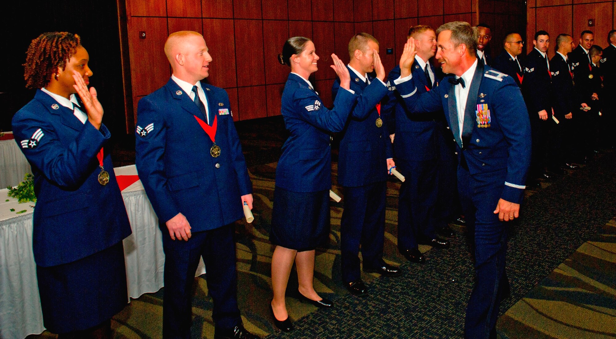 Col. Mark O’Laughlin, 325th Fighter Wing vice commander, gives a high five to the members of Airman Leadership Class 14-3 March 27 at the Horizons Community Center during the conclusion of their graduation ceremony. (U.S. Air Force photo by Staff Sgt. Rachelle Blake)