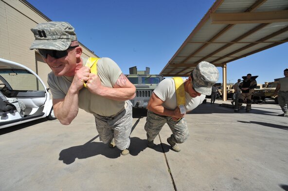 Capt. Edmund Spivak and Staff Sgt. Joe Hernandez, 56th Civil Engineer Squadron Explosive Ordnance Disposal members, pull an up-armored Humvee, one of the featured events May 2 in the Warrior PT Challenge. (U.S. Air Force photo illustration/Senior Airman Jason Colbert)