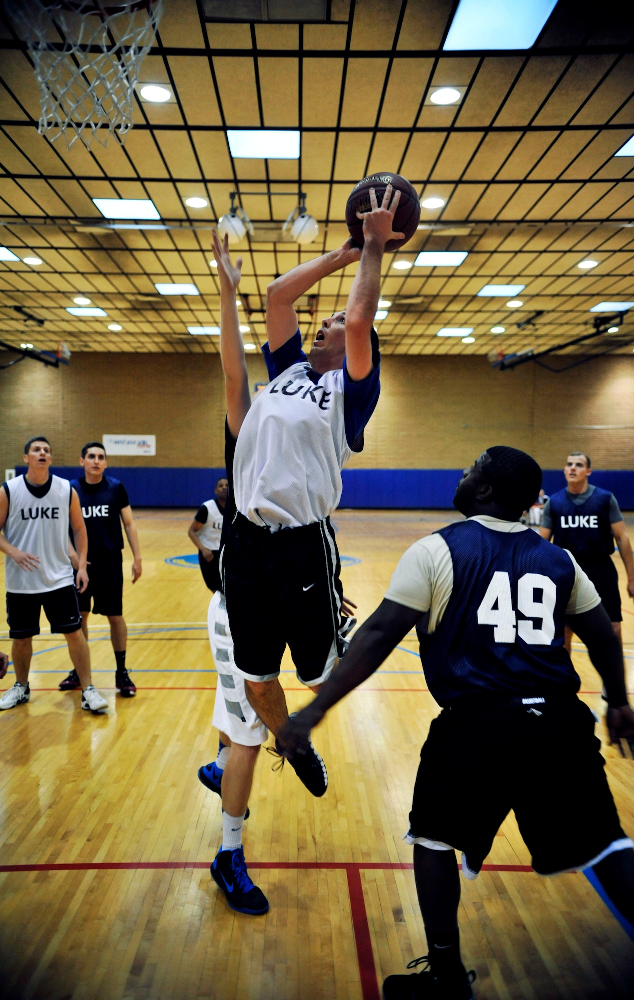 Jeremy Sharron, 56th Equipment Maintenance Squadron, shoots the ball over two 56th Security Forces Squadron defenders during the first half of the intramural basketball game March 18 at the Luke Air Force Base Bryant Fitness Center. (U.S. Air Force photo/Senior Airman David Owsianka)