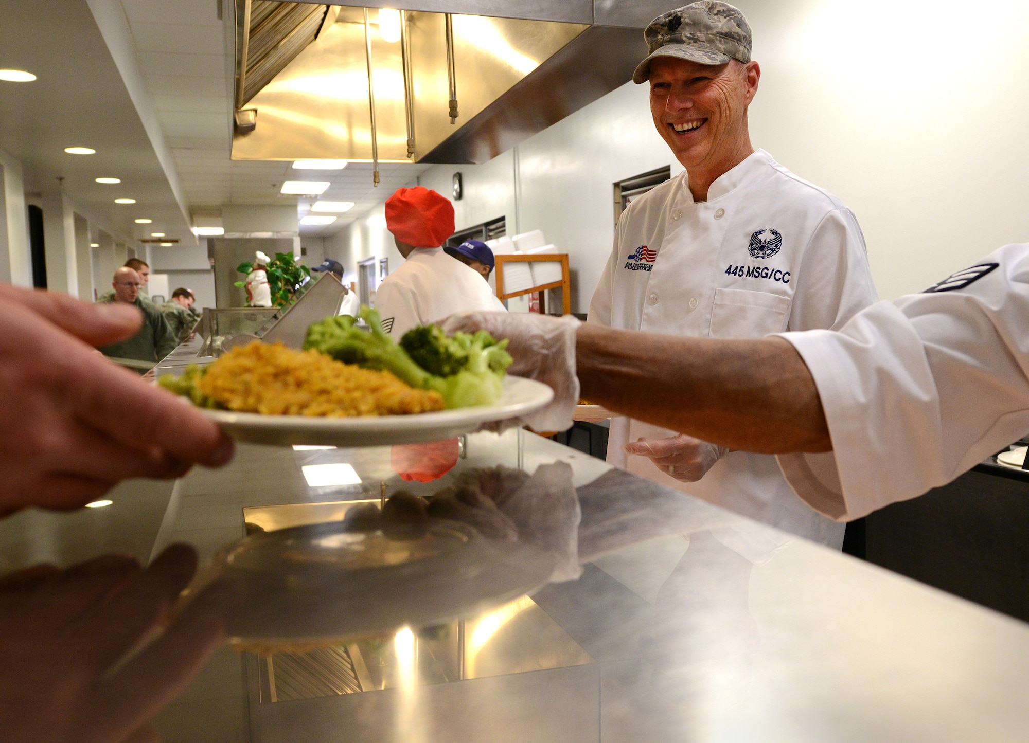 WRIGHT-PATTERSON AIR FORCE BASE, Ohio - Lt. Col. Dale Bateman, 445th Mission Support Group commander, serves Airmen during the March 8, 2014 lunch hour at the Pitsenbarger Dining Facility here. Bateman was taking part in the “Serve It Up Initiative.” The project helps boost morale and gives the commanders and first sergeants a chance to sport their new chef's coats. The initiative will go on indefinitely and the coats will be inherited by future commanders when they join the unit. (U.S. Air Force photo/Tech. Sgt. Frank Oliver)