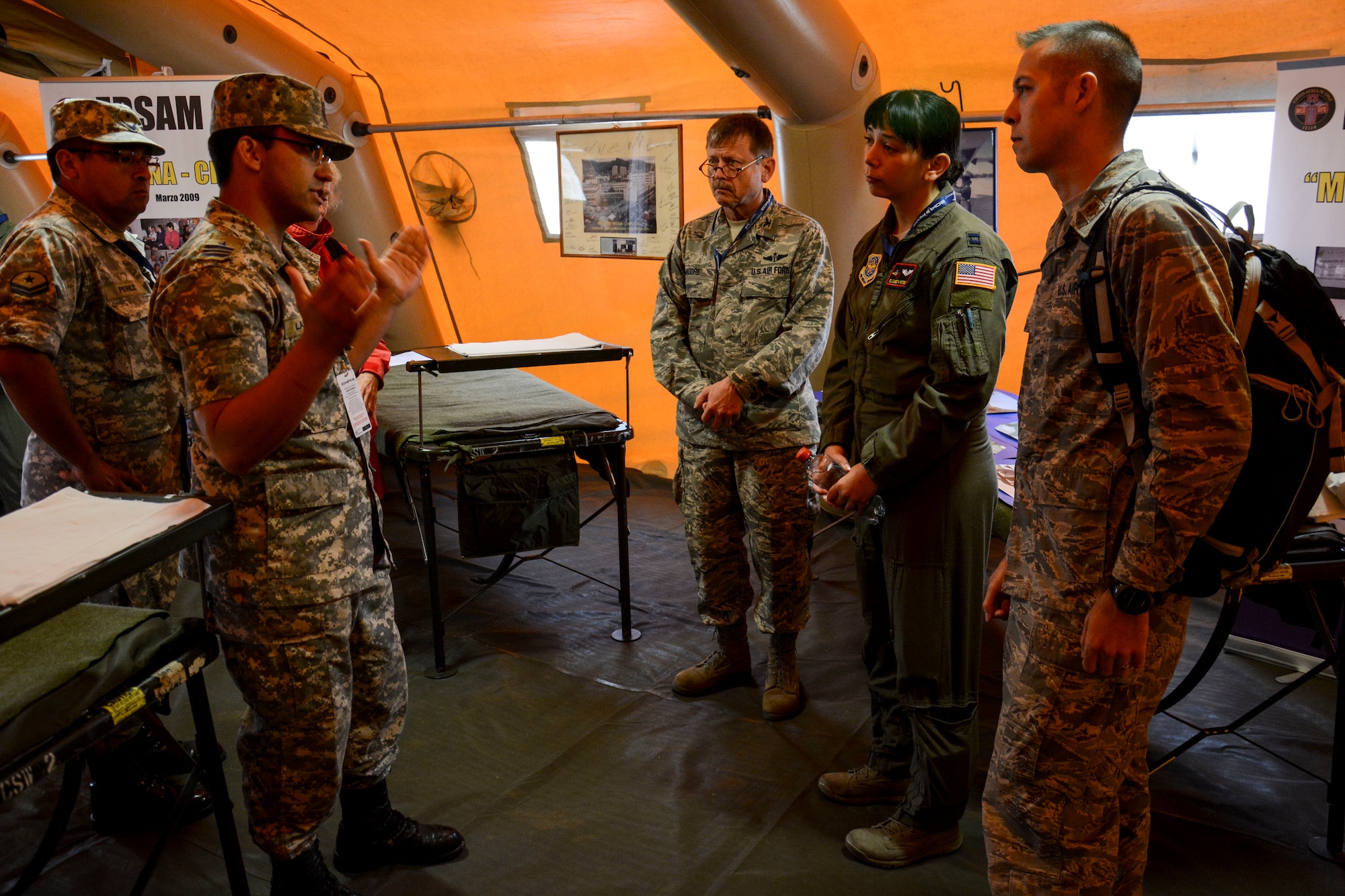 Col. Garry Moore, a flight surgeon with the Texas Air National Guard, Capt. Elizabeth Peters, Aeromedical Evacuation Air Advisor for the 571st Mobility Support Advisory Squadron, and Maj. Mike Hampton, a flight surgeon serving on an exchange program with the Chilean air force, discuss deployed medical support with a Chilean air force officer in Santiago, Chile, March 27.  Nearly 60 U.S. airmen are participating in discussions with Chilean air force counterparts this week, and as part of the events are hosting static displays of the C-130 Hercules and F-16 Fighting Falcon during the FIDAE Air Show March 25 to 30. (U.S. Air Force photo by Capt. Justin Brockhoff/Released)