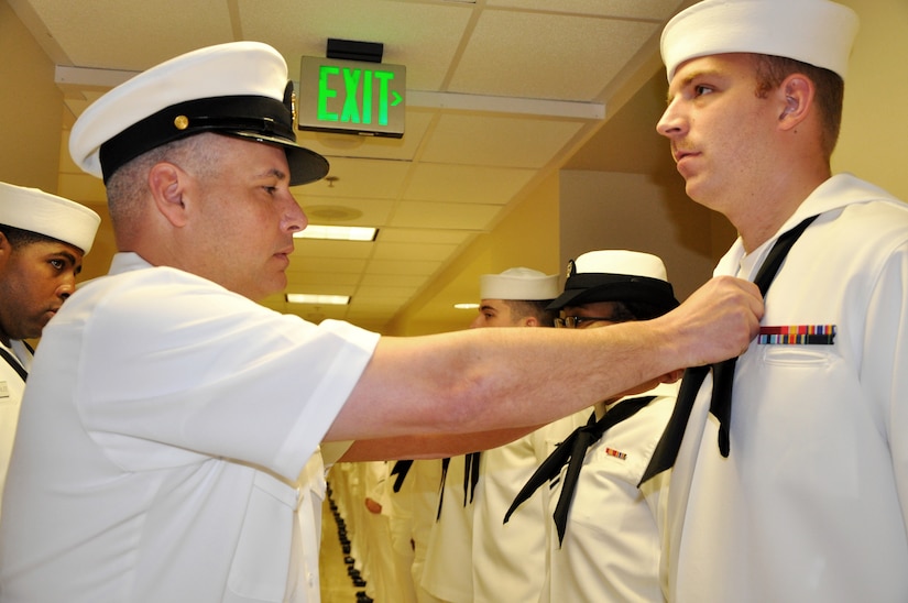 Senior Chief Petty Officer Tommy Wagers, Naval Health Clinic Charleston Directorate for Administration senior enlisted leader, adjusts Seaman Christopher Connelly’s neckerchief prior to a command-wide uniform inspection March 28, 2014, at NHCC on Joint Base Charleston – Weapons Station, S.C. Connelly is a Hospital Corpsman assigned to NHCC. (U.S. Navy photo/Petty Officer 3rd Class Caralyn Mulyk)