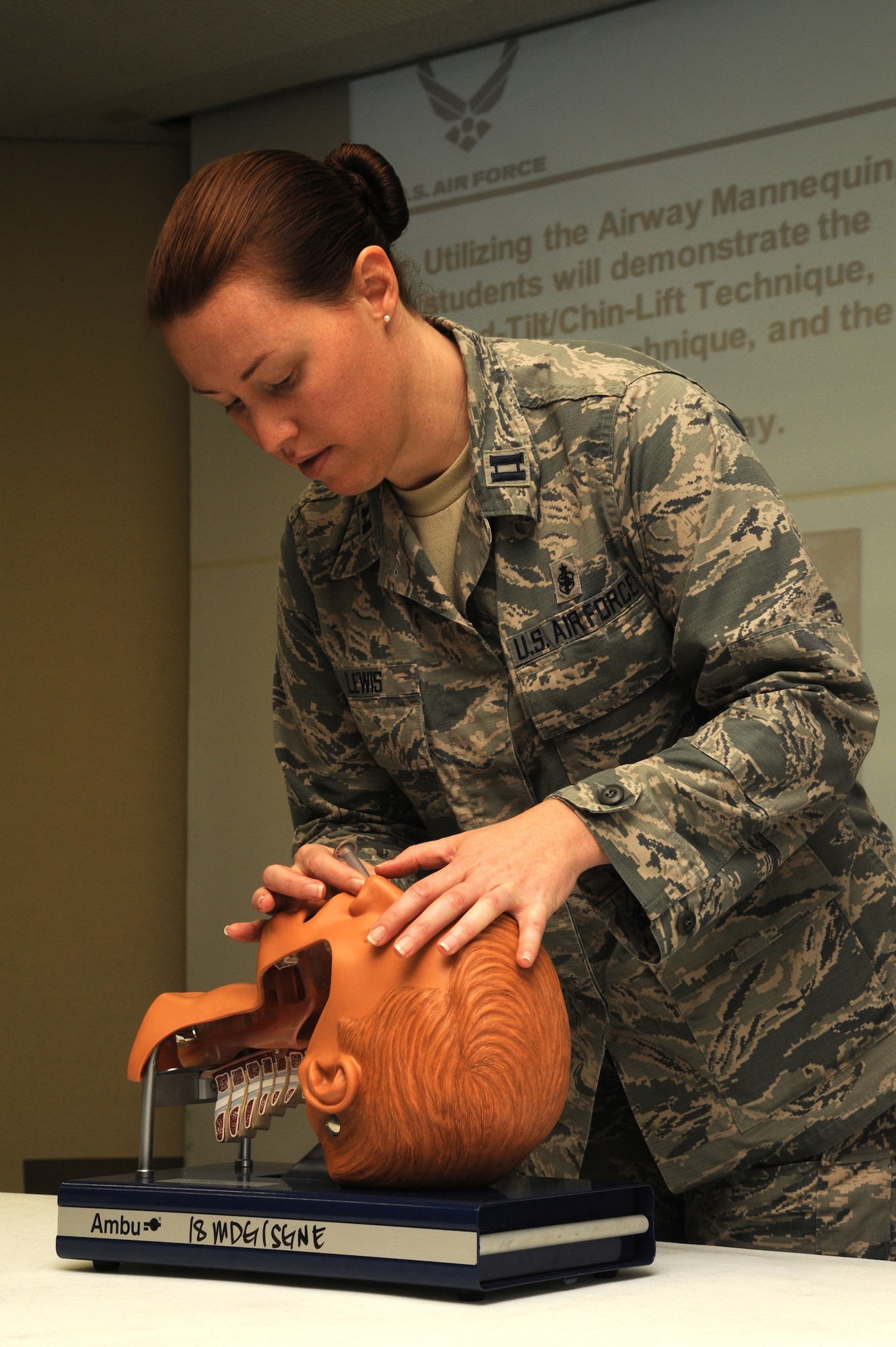 U.S. Air Force Capt. Micaela Lewis, 18th Medical Group medical readiness flight commander, demonstrates the ?head tilt, chin lift? technique during a self-aid and buddy care class on Kadena Air Base, Japan, March 27, 2014. Airmen are required to take the hands-on portion of the training every two years or before a deployment. The class provides Airmen an opportunity to learn how manage injuries until help arrives. (U.S. Air Force photo by Airman 1st Class Zackary A. Henry)