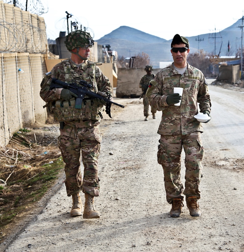 U.S. Army Lt. Col. Robert Owen, left, walks to the Operation Coordination Center's headquarters on Forward Operating Base Thunder in Afghanistan's Paktia province, March 26, 2014. Owens is commander of 10th Mountain Division's Operation Coordination Center-Regional Security Force Advise and Assist team, 3rd Brigade Combat Team.