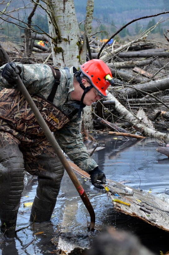 Air Force Staff Sgt. Steve Jarman removes debris from the sludge while searching for survivors in Oso, Wash., March 28, 2014, following a deadly mudslide. Jarman is assigned to the Washington National Guard's 141st Air Refueling Wing.