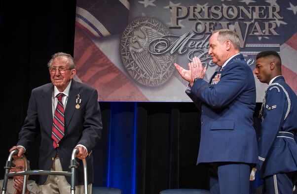 Air Force Chief of Staff Gen. Mark A. Welsh III applauds retired Lt. Col. James I. Misuraca after presenting him with the Prisoner of War Medal during a ceremony April 30, 2014, at the Pentagon. Misuraca, a former bomber crew member, was shot down while flying missions over Germany and was held in a prison camp in Wauwilermoos, Switzerland. (U.S. Air Force photo/Jim Varhegyi)
