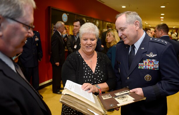 Francine Munster shows Air Force Chief of Staff Gen. Mark A. Welsh III an album containing historical documents and photographs following a POW Medal ceremony, April 30, 2014, at the Pentagon. Munster is the daughter of Col. James Mahafee, who was posthumously awarded the medal. Mahafee and eight other World War II aviators were recognized during the ceremony. The bomber crew members were shot down while flying missions over Germany and were held in a prison camp in Wauwilermoos, Switzerland. For decades, the men were denied POW status. (U.S. Air Force photo/Scott M. Ash)