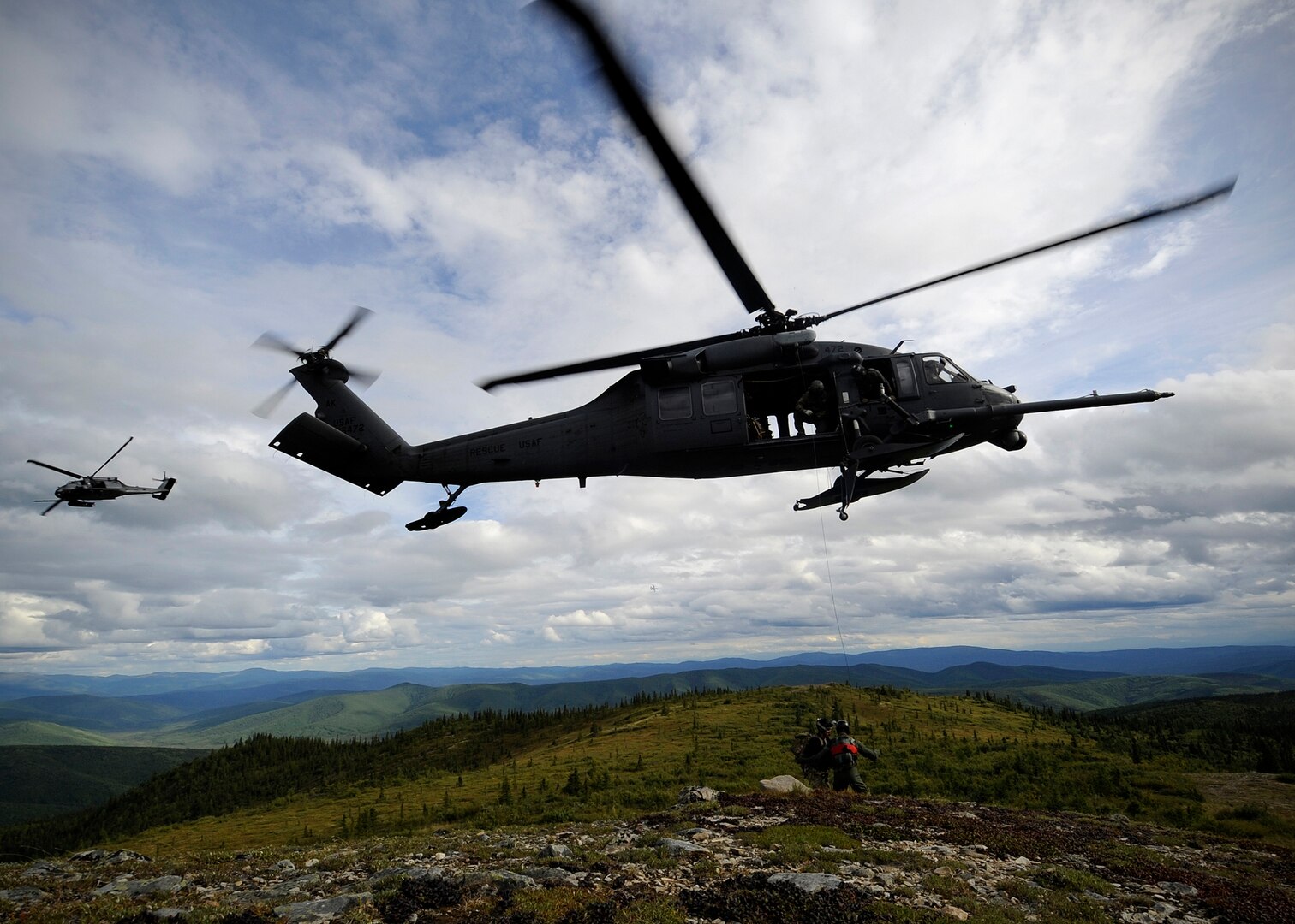 Two U.S. Air Force HH-60 Black Hawk helicopters from the 210th Rescue Squadron, Eielson Air Force Base, Alaska, arrive to rescue a simulated downed pilot during RED FLAG-Alaska 13-3, Aug. 22, 2013. Earlier in the week, a unit helicopter helped rescue four men from a glacier.