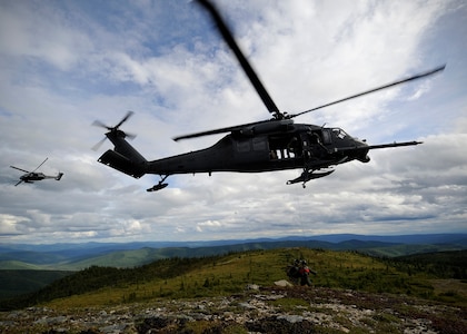 Two U.S. Air Force HH-60 Black Hawk helicopters from the 210th Rescue Squadron, Eielson Air Force Base, Alaska, arrive to rescue a simulated downed pilot during RED FLAG-Alaska 13-3, Aug. 22, 2013. Earlier in the week, a unit helicopter helped rescue four men from a glacier.