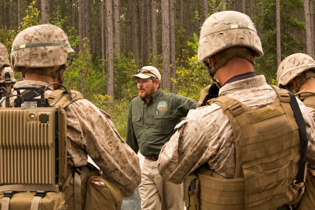 Paul Albaugh, a counter improvised explosive device instructor with the Marine Corps Engineer School’s Counter Improvised Explosive Device Training, speaks to Marines after they complete an exercise at a training area in Holly Ridge, N.C., April 25. Marines in any unit in the Marine Corps Base Camp Lejeune area can participate in a variety of courses held by the school. 