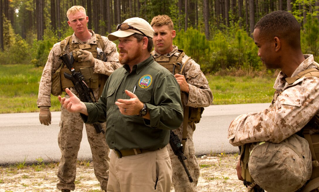 Paul Albaugh, a counter improvised explosive device instructor with the Marine Corps Engineer School’s Counter Improvised Explosive Device Training, speaks to Marines after they complete an exercise at a training area in Holly Ridge, N.C., April 25. Marines in any unit in the Marine Corps Base Camp Lejeune area can participate in a variety of courses held by the school. 