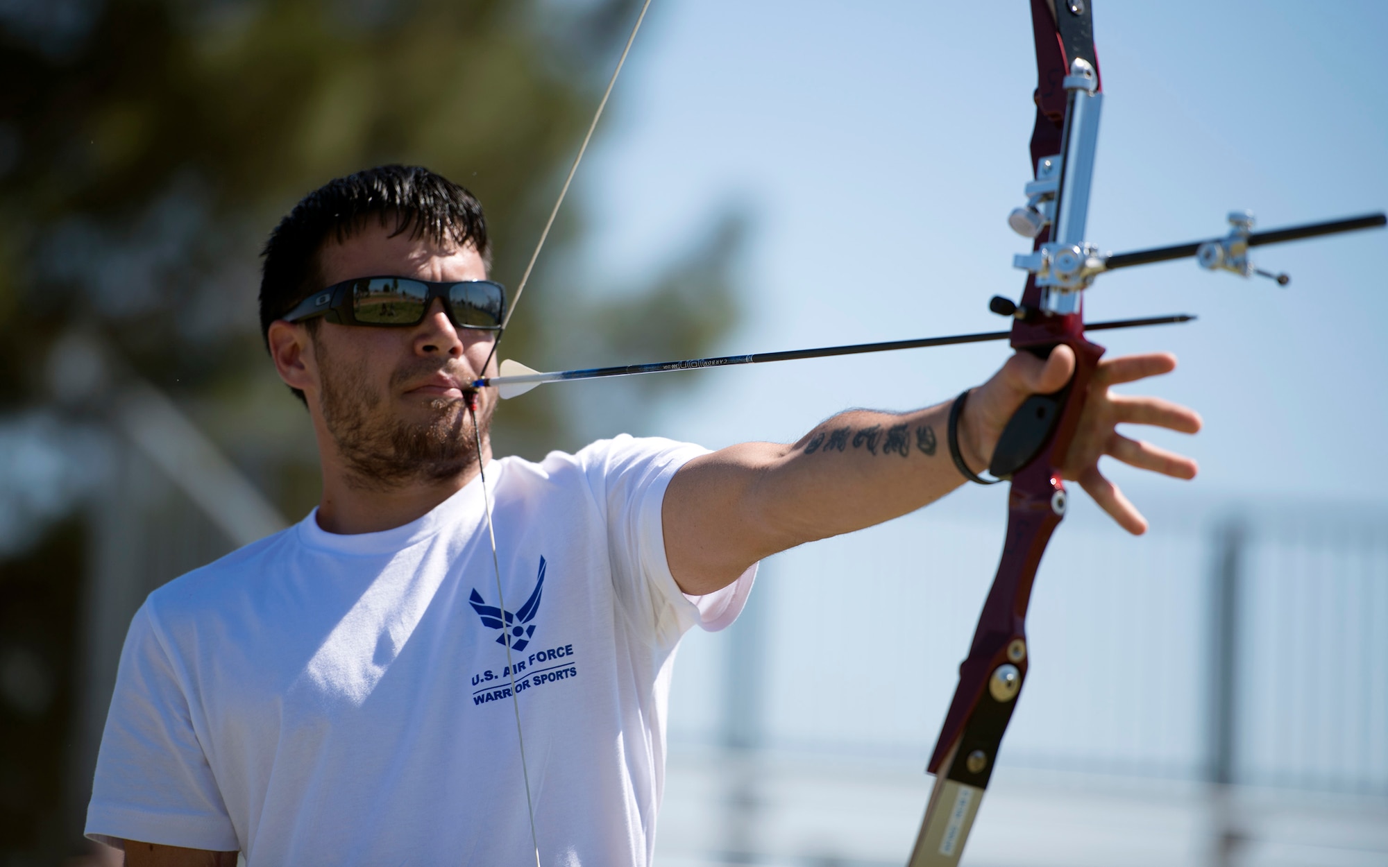 Retired Staff Sgt. Daniel Crane draws an arrow back using a mouthpiece during the Air Force Trials April 10, 2014, at Nellis Air Force Base, Nev.  After a gunshot wound left his right forearm and hand immobile, Crane immersed himself in adaptive sports, where he has learned new ways to overcome his limitations.  (U.S. Air Force photo/Senior Airman Jette Carr) 