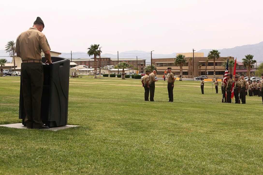 Maj. Gen. David H. Berger, Marine Air Ground Task Force Training Command, Marine Corps Air Ground Combat Center Commanding General, presents the Navy Cross to Gunnery Sgt. Richard A. Jibson, Battle Staff Training Program team member, Marine Corps Tactics and Operations Group, during an award ceremony held at Lance Corporal Torrey L. Gray Field April 22, 2014. Jibson was advising a 53-man coalition force of Georgian, Afghan, and United States Personnel during the clearing of an Afghan village, May 28, 2012, when he unhesitatingly chose to protect, rescue and inspire his Marines throughout a 5-hour long fire fight. (Official Marine Corps photo by Cpl. Charles Santamaria/Released)