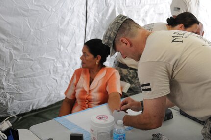 U. S. Army Maj. Scott Gadberry performs a blood sugar screening test for a Honduran woman.  Joint Task Force-Bravo's Medical Element (MEDEL), with support from all Joint Task Force-Bravo commands, hosted the Soto Cano Air Base Senior Health Engagement providing valuable health and wellness information, a base tour, and some entertainment to 133 Honduran senior citizens from Cane, La Paz, April 30.  The group received health screenings and patient education related to blood pressure, blood sugar, exercise, muscle strength, balance and good oral hygiene as they age.  After the screenings and classes were finished, the group of senior citizens was able to turn back the hands of time and act young again as they were treated to dance lessons and the opportunity to dance with members from Joint Task Force-Bravo.  (Photo by U. S. Air National Guard Capt. Steven Stubbs)