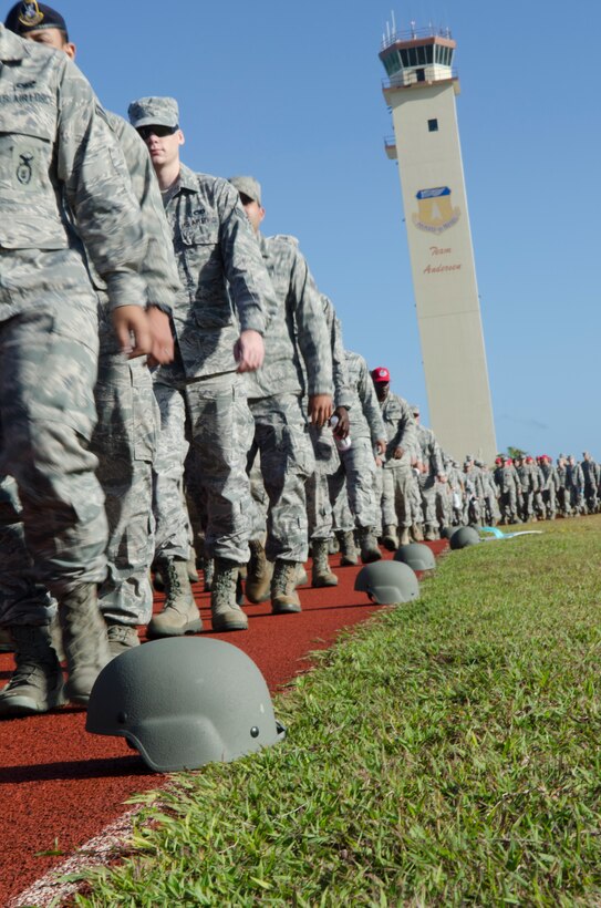 Airmen walk past helmets placed on the track during the 2014 Sexual Assault Prevention and Response Down-Day April 25, 2014, on Andersen Air Force Base, Guam. The helmets were a visual representation of individuals who have opened up reports since the implementation of the Sexual Assault Prevention and Response program at Andersen in 2006. (U.S. Air Force photo by Senior Airman Katrina M. Brisbin/Released)