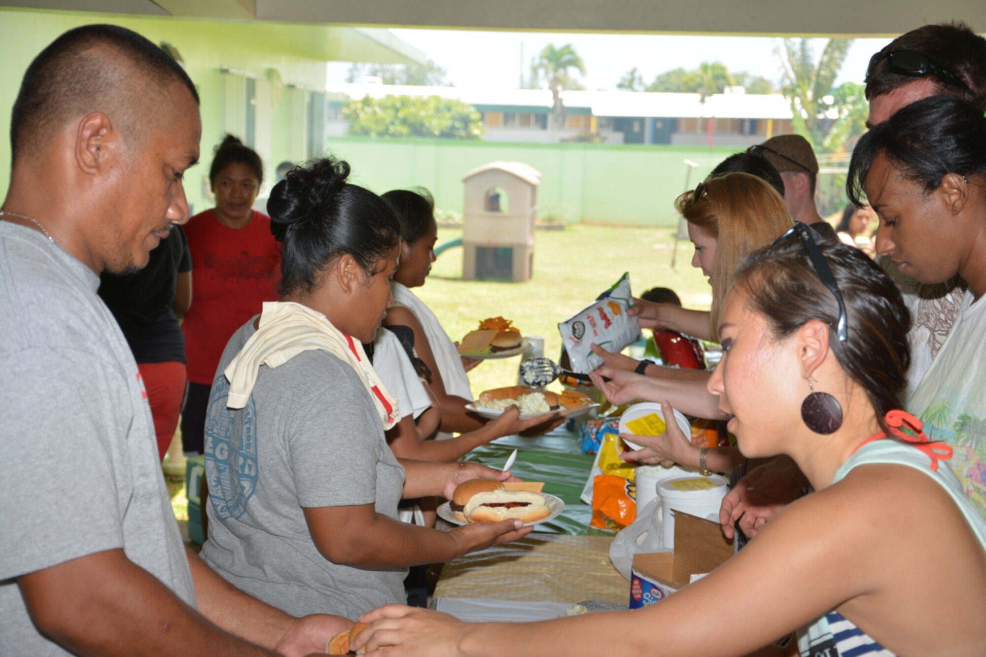 Members of the 36th Operations Support Squadron and family members serve barbecue meals to residents of the Guma San Jose Homeless Shelter in Dededo, Guam, April 12, 2014. The squadron volunteers assist shelter residents each quarter, providing meals as well as serving and cleaning. (U.S. Air Force courtesy photo/Released)