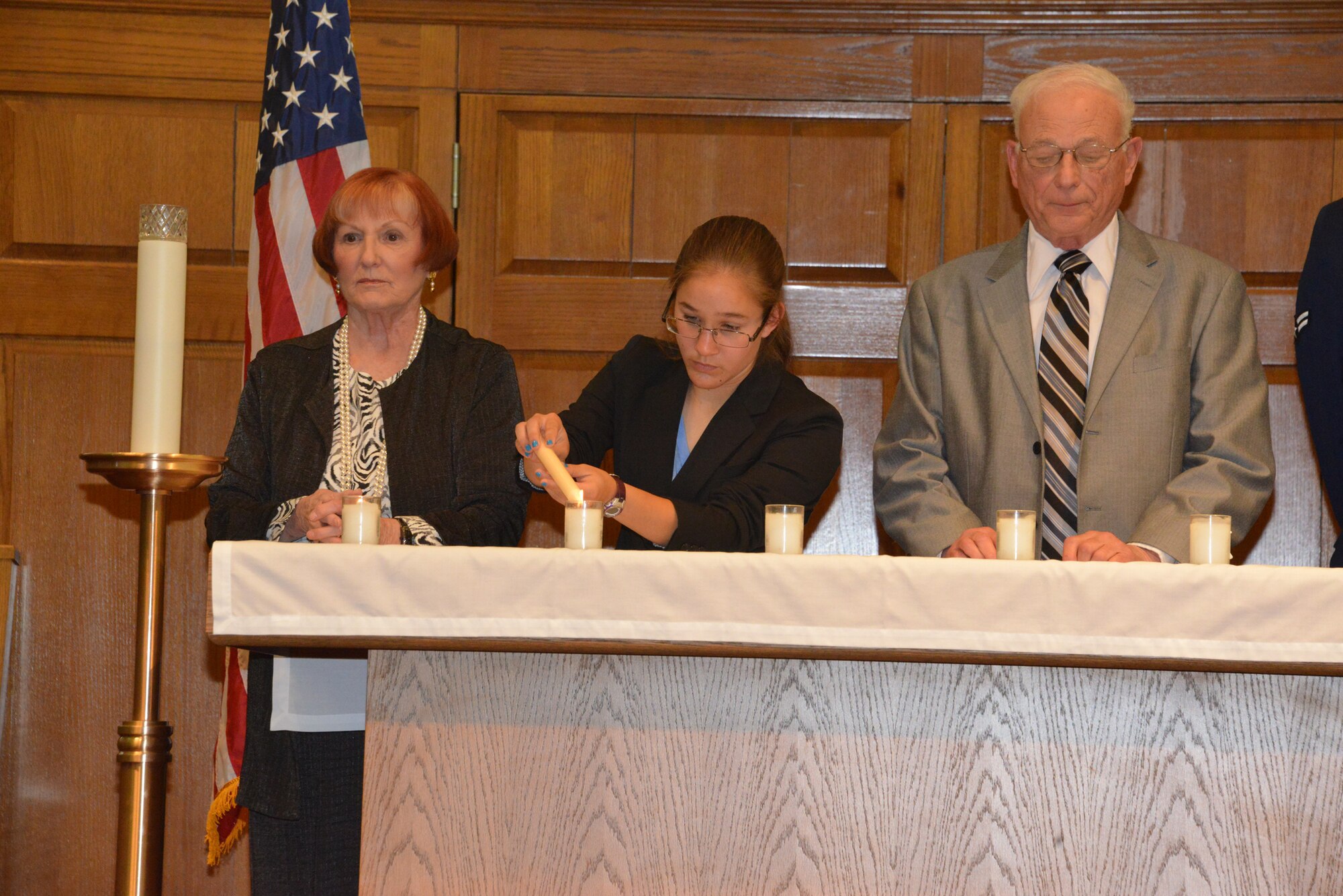 Guest speakers (left to right) Raya Kovensky, Madeline Cunnings and Noel Pugach light candles at the Holocaust Remembrance Day ceremony at the Base Chapel April 30. (Photo by Dennis Carlson)