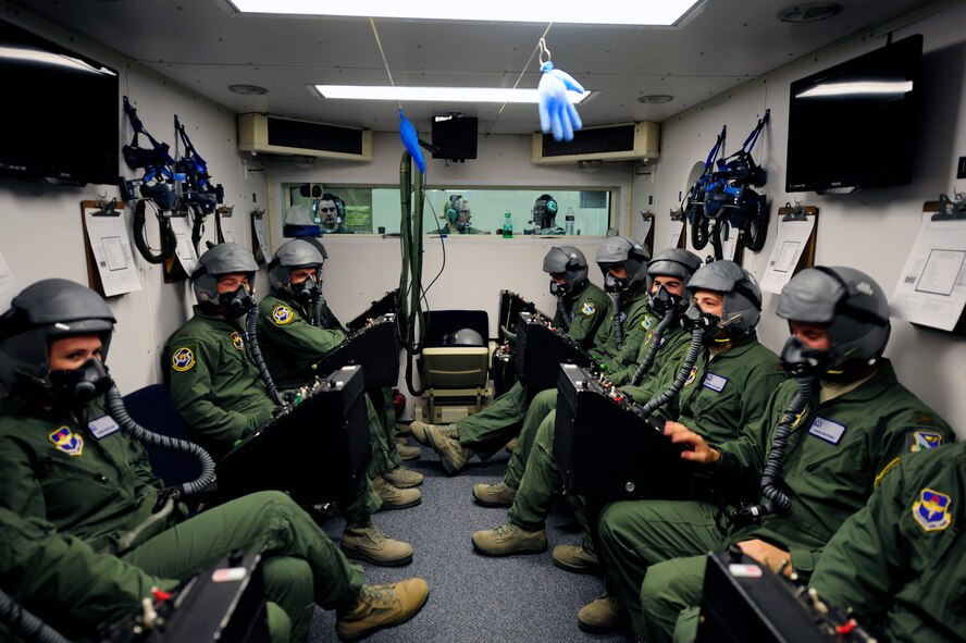 Student pilots, 47th Student Squadron Class 15-09, complete a communications check in the hypobaric chamber at the Aerospace Physiology Unit on Laughlin Air Force Base, Texas, April 30, 2014. New aircrew will undergo a familiarization profile, where the chamber mimics the air pressure at 10,000 ft. and students are asked to yawn. It then mimics the air pressure during descent and the students must perform the valsalva maneuver to "clear" the ears and sinuses when ambient pressure changes. (U.S. Air Force photo/Airman 1st Class Ariel D. Delgado/Released)