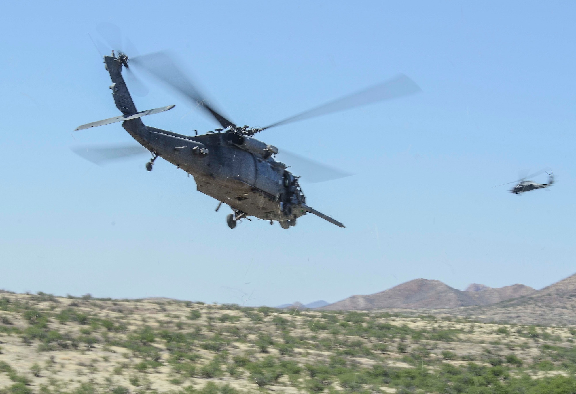 After extracting a downed pilot two HH-60’s return to Davis-Monthan Air Force Base, during a Combat Search and Rescue Exercise in Southern Ariz., April 29, 2014. The main objective of this exercise was to effectively integrate communications across joint platforms to authenticate, locate and protect isolated personnel while successfully extracting them. (U.S. Air Force photo by Staff Sgt. Adam Grant/Released)