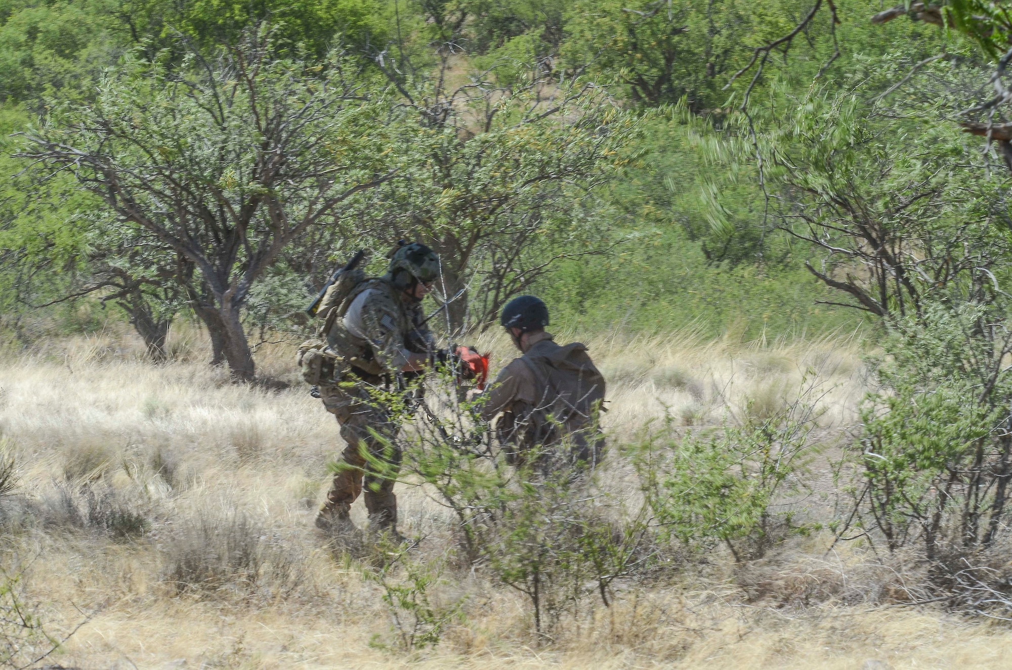 A pararescuemen fastens in Maj. John Reed, 12th Air Force (Air Forces Southern) executive officer, and prepares to hoist him up in to a HH-60 during a Combat Search and Rescue Exercise in Southern Ariz., April 29, 2014. The main objective of this exercise was to effectively integrate communications across joint platforms to authenticate, locate and protect isolated personnel while successfully extracting them. (U.S. Air Force photo by Staff Sgt. Adam Grant/Released)