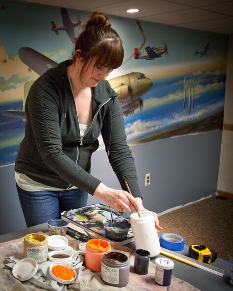 Muralist Lili Payne puts the finishing touches on a new painting in the Officers' Club at Ft. Snelling.  The Air Force Association E.W. Rawlings chapter raised funds to commission the mural at the Minneapolis-St. Paul Air Reserve Station, Minn.  (U.S. Air Force photo by Shannon McKay/Released)
