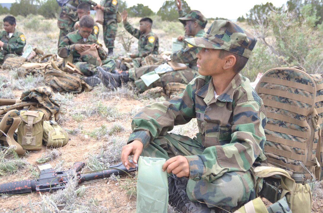 The Young Marines,  a group of 14 boys and a girl ranging in age from 8 to 15, learn the art of camouflage from a Marine from the 4th Reconnaissance Battalion’s Delta Company, part of the Marine Forces Reserve, at Kirtland April 26 for the Enchanted Hills Young Marines. (Photo by Lee Ross)