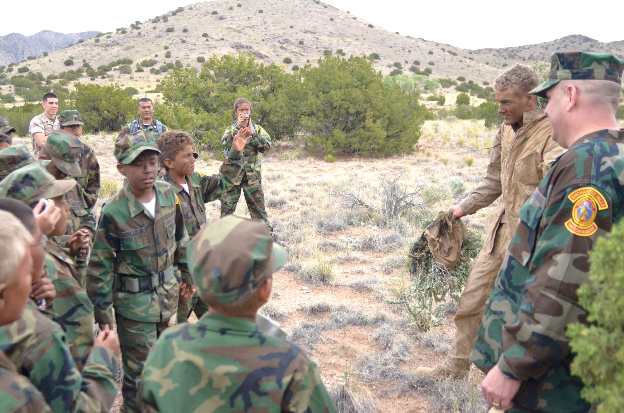A Marine from the 4th Reconnaissance Battalion’s Delta Company, part of the Marine Forces Reserve, demonstrates his ability to hide as part of a presentation at Kirtland April 26 for the Enchanted Hills Young Marines. (Photo by Lee Ross)