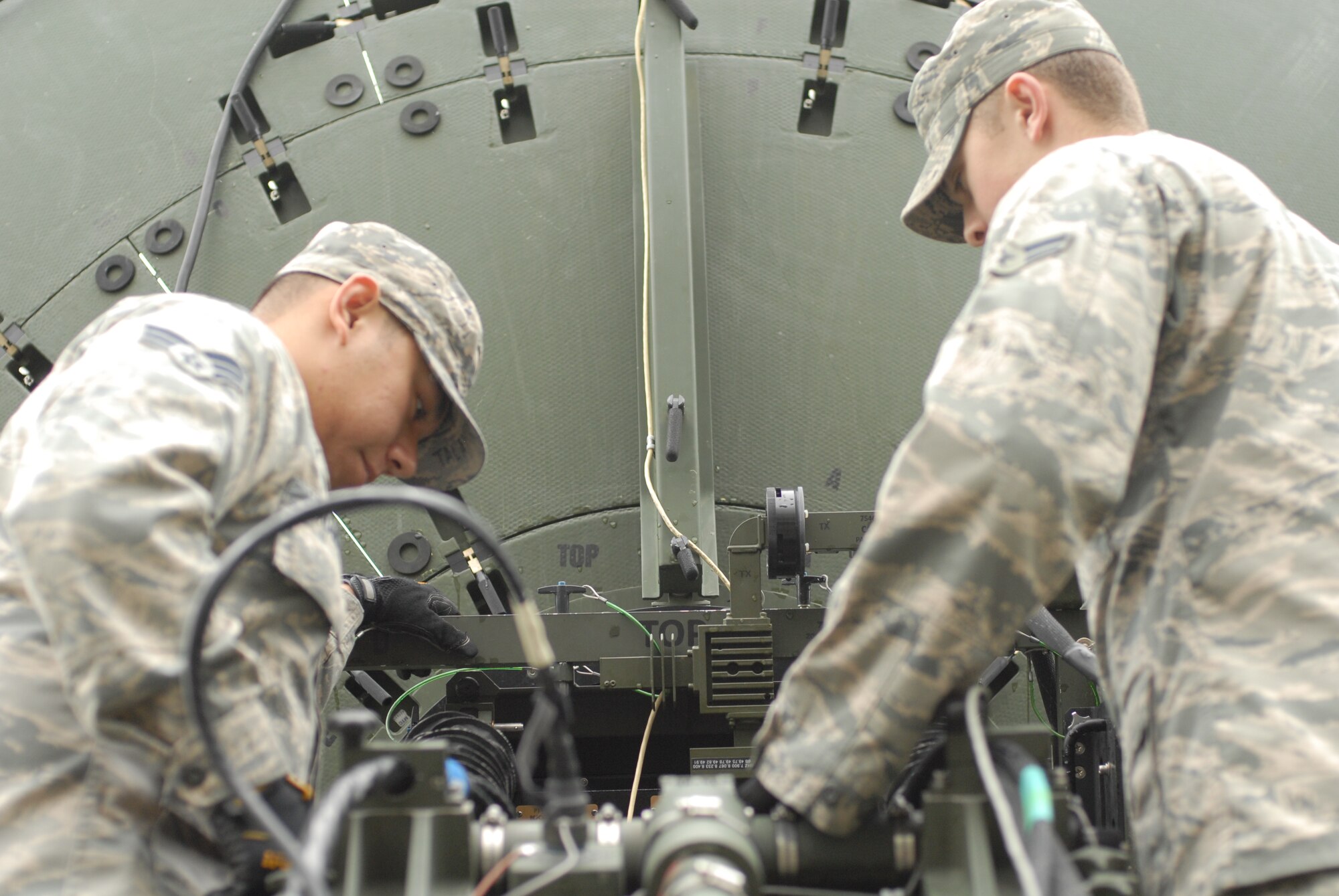 Senior Airman Joseph Mark Talampas, 607th Support Squadron transmissions radio frequencies technician, and Airman 1st Class Brendan Wood, 607th SPTS transmission systems apprentice, inspect a newly repaired antenna prior to testing its satellite accessioning capability on Osan Air Base, Republic of Korea, April 28, 2014. The 607th SPTS reached out to the 51st Logistics Readiness Squadron Vehicle Management in order to help repair the antenna, which is critical to the base’s communication systems.  (U.S. Air Force photo / 1st Lt. Kay M. Nissen)