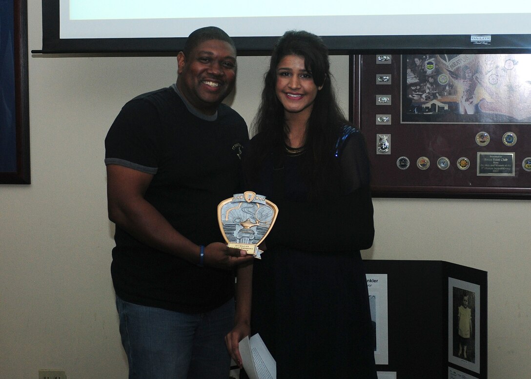 Terrel Love, Holocaust Remembrance Committee member, presents Jagreet Sekhon, Yuba City High School student, with a plaque for being the 2014 Beale Air Force Base Holocaust Remembrance Essay Award winner at the Recce Point Club May 1, 2014. Sekhon was a guest speaker for the event. (U.S. Air Force photo by Senior Airman Allen Pollard/Released)