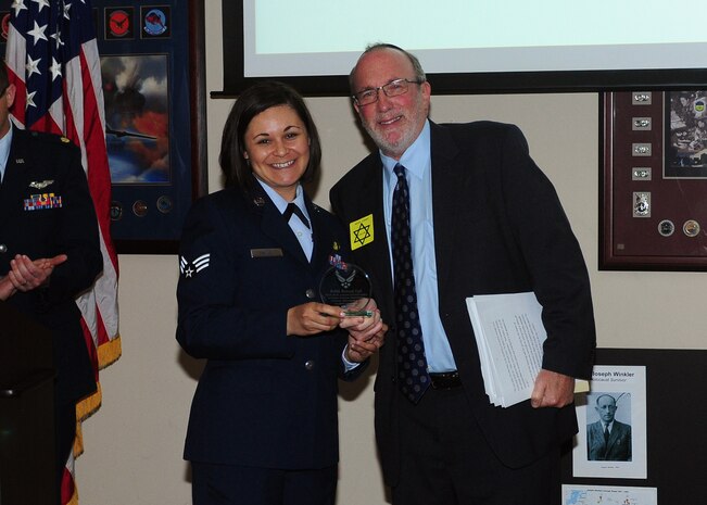 Senior Airman Kaitlin Massey, Holocaust Remembrance Committee member, presents Reuven Taff, Mosaic Law Congregation rabbi and spiritual leader, with a token of appreciation during the Holocaust Remembrance Breakfast at the Recce Point Club on Beale Air Force Base, Calif., May 1, 2014. Taff was a guest speaker for the event. (U.S. Air Force photo by Senior Airman Allen Pollard/Released)