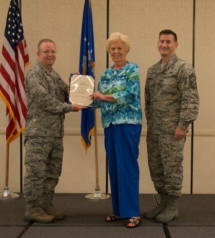Col. Jeffrey DeVore, Joint Base Charleston commander (left) and  Chief Master Sgt. Mark Bronson, 628th Air Base Wing command chief, present the Volunteer Excellence Award to Marion Jones May 1, 2014, at the Charleston Club on Joint Base Charleston – Air Base, S.C. The 628th ABW Quarterly Awards are held to recognize outstanding Airmen, noncommisioned officers, senior noncomissioned officers, company grade officers and civilians for their hard work and dedication. (U.S. Air Force photo/ Airman 1st Class Clayton Cupit)