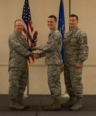 Col. Jeffrey DeVore, Joint Base Charleston commander (left), and Chief Master Sgt. Mark Bronson, 628th Air Base Wing command chief, present the Honor Guard Member of the Quarter Award to Airman 1st Class Matthew Taresh from the 437th Aircraft Maintenance Squadron May 1, 2014, at the Charleston Club on Joint Base Charleston – Air Base, S.C. The 628th ABW Quarterly Awards are held to recognize outstanding Airmen, noncommisioned officers, senior noncomissioned officers, company grade officers and civilians for their hard work and dedication. (U.S. Air Force photo/ Airman 1st Class Clayton Cupit)
