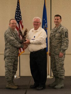 Col. Jeffrey DeVore, Joint Base Charleston commander (right), and  Chief Master Sgt. Mark Bronson, 628th Air Base Wing command chief, present the Volunteer of the Quarter to David Tollinger from the 628th Medical Support Squadron May 1, 2014, at the Charleston Club on Joint Base Charleston – Air Base, S.C. The 628th ABW Quarterly Awards are held to recognize outstanding Airmen, noncommisioned officers, senior noncomissioned officers, company grade officers and civilians for their hard work and dedication. (U.S. Air Force photo/ Airman 1st Class Clayton Cupit)