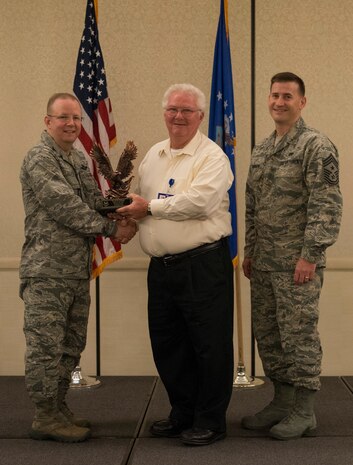 Col. Jeffrey DeVore, Joint Base Charleston commander (right), and  Chief Master Sgt. Mark Bronson, 628th Air Base Wing command chief, present the Volunteer of the Quarter to David Tollinger from the 628th Medical Support Squadron May 1, 2014, at the Charleston Club on Joint Base Charleston – Air Base, S.C. The 628th ABW Quarterly Awards are held to recognize outstanding Airmen, noncommisioned officers, senior noncomissioned officers, company grade officers and civilians for their hard work and dedication. (U.S. Air Force photo/ Airman 1st Class Clayton Cupit)
