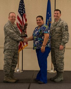 Col. Jeffrey DeVore, Joint Base Charleston commander (left), and Chief Master Sgt. Mark Bronson, 628th Air Base Wing command chief, present the Category II Civilian of the Quarter Award to Lillian Rivera-Jackson from the 628th Medical Operations Squadron May 1, 2014, at the Charleston Club on Joint Base Charleston – Air Base, S.C. The 628th ABW Quarterly Awards are held to recognize outstanding Airmen, noncommisioned officers, senior noncomissioned officers, company grade officers and civilians for their hard work and dedication. (U.S. Air Force photo/ Airman 1st Class Clayton Cupit)