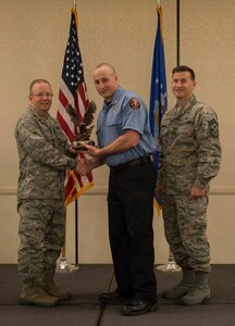 Col. Jeffrey DeVore, Joint Base Charleston commander (left), and Chief Master Sgt. Mark Bronson, 628th Air Base Wing command chief, present the Category I Civilian of the Quarter Award to Matthew Coleman from the 628th Civil Engineer Squadron May 1, 2014, at the Charleston Club on Joint Base Charleston – Air Base, S.C. The 628th ABW Quarterly Awards are held to recognize outstanding Airmen, noncommisioned officers, senior noncomissioned officers, company grade officers and civilians for their hard work and dedication. (U.S. Air Force photo/ Airman 1st Class Clayton Cupit)