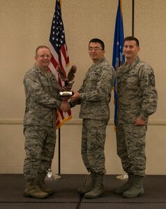 Col. Jeffrey DeVore, Joint Base Charleston commander (left), and Chief Master Sgt. Mark Bronson, 628th Air Base Wing command chief, present the Company Grade Officer of the Quarter Award to 2nd Lt. Abror Samatov from the 628th Contracting Squadron May 1, 2014, at the Charleston Club on Joint Base Charleston – Air Base, S.C. The 628th ABW Quarterly Awards are held to recognize outstanding Airmen, noncommisioned officers, senior noncomissioned officers, company grade officers and civilians for their hard work and dedication. (U.S. Air Force photo/ Airman 1st Class Clayton Cupit)