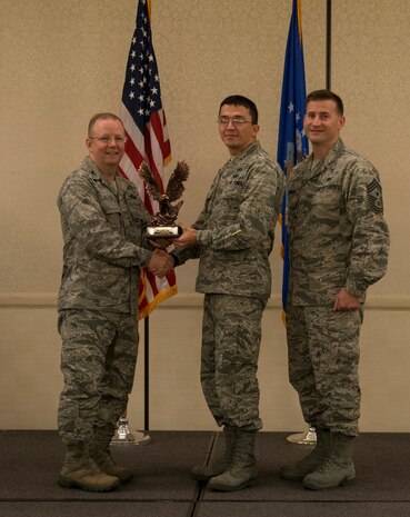 Col. Jeffrey DeVore, Joint Base Charleston commander (left), and Chief Master Sgt. Mark Bronson, 628th Air Base Wing command chief, present the Company Grade Officer of the Quarter Award to 2nd Lt. Abror Samatov from the 628th Contracting Squadron May 1, 2014, at the Charleston Club on Joint Base Charleston – Air Base, S.C. The 628th ABW Quarterly Awards are held to recognize outstanding Airmen, noncommisioned officers, senior noncomissioned officers, company grade officers and civilians for their hard work and dedication. (U.S. Air Force photo/ Airman 1st Class Clayton Cupit)