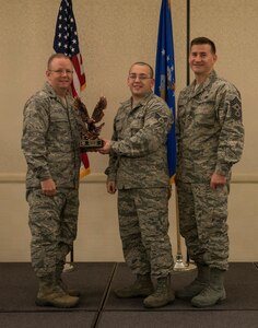 Col. Jeffrey DeVore, Joint Base Charleston commander (left), and Chief Master Sgt. Mark Bronson, 628th Air Base Wing command chief, present the Airman of the Quarter Award to Senior Airman Thomas Moore from the 628th Medical Support Squadron May 1, 2014, at the Charleston Club on Joint Base Charleston – Air Base, S.C. The 628th ABW Quarterly Awards are held to recognize outstanding Airmen, noncommisioned officers, senior noncomissioned officers, company grade officers and civilians for their hard work and dedication. (U.S. Air Force photo/ Airman 1st Class Clayton Cupit)