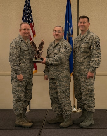 Col. Jeffrey DeVore, Joint Base Charleston commander (left), and Chief Master Sgt. Mark Bronson, 628th Air Base Wing command chief, present the Airman of the Quarter Award to Senior Airman Thomas Moore from the 628th Medical Support Squadron May 1, 2014, at the Charleston Club on Joint Base Charleston – Air Base, S.C. The 628th ABW Quarterly Awards are held to recognize outstanding Airmen, noncommisioned officers, senior noncomissioned officers, company grade officers and civilians for their hard work and dedication. (U.S. Air Force photo/ Airman 1st Class Clayton Cupit)