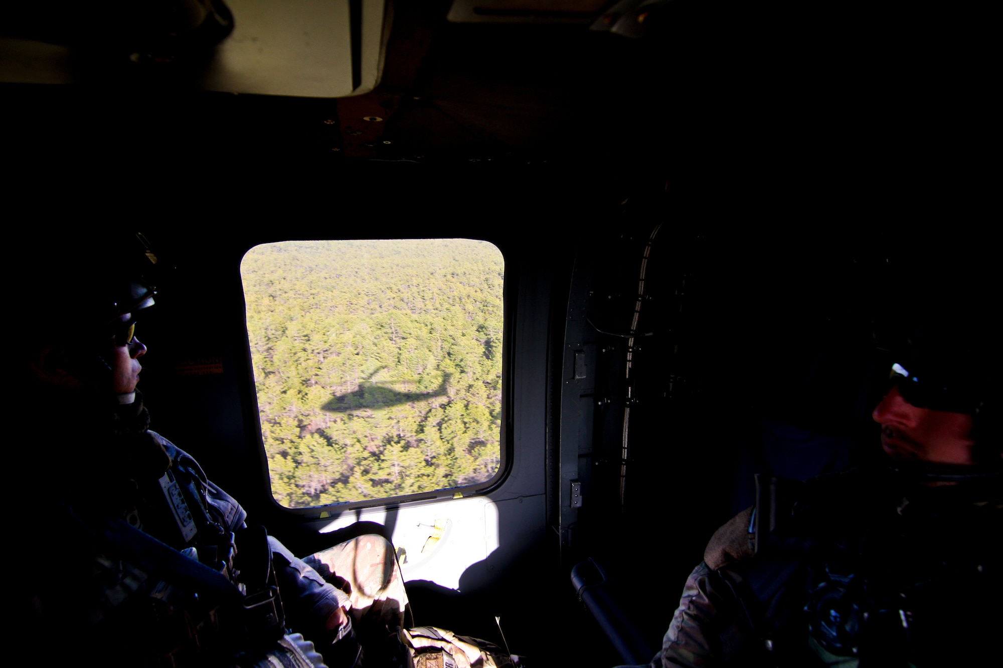 A picture of U.S. Air Force Staff Sgt. Kane Lawlor and Senior Airman Sean Meehan flying on a UH-60 Black Hawk helicopter.