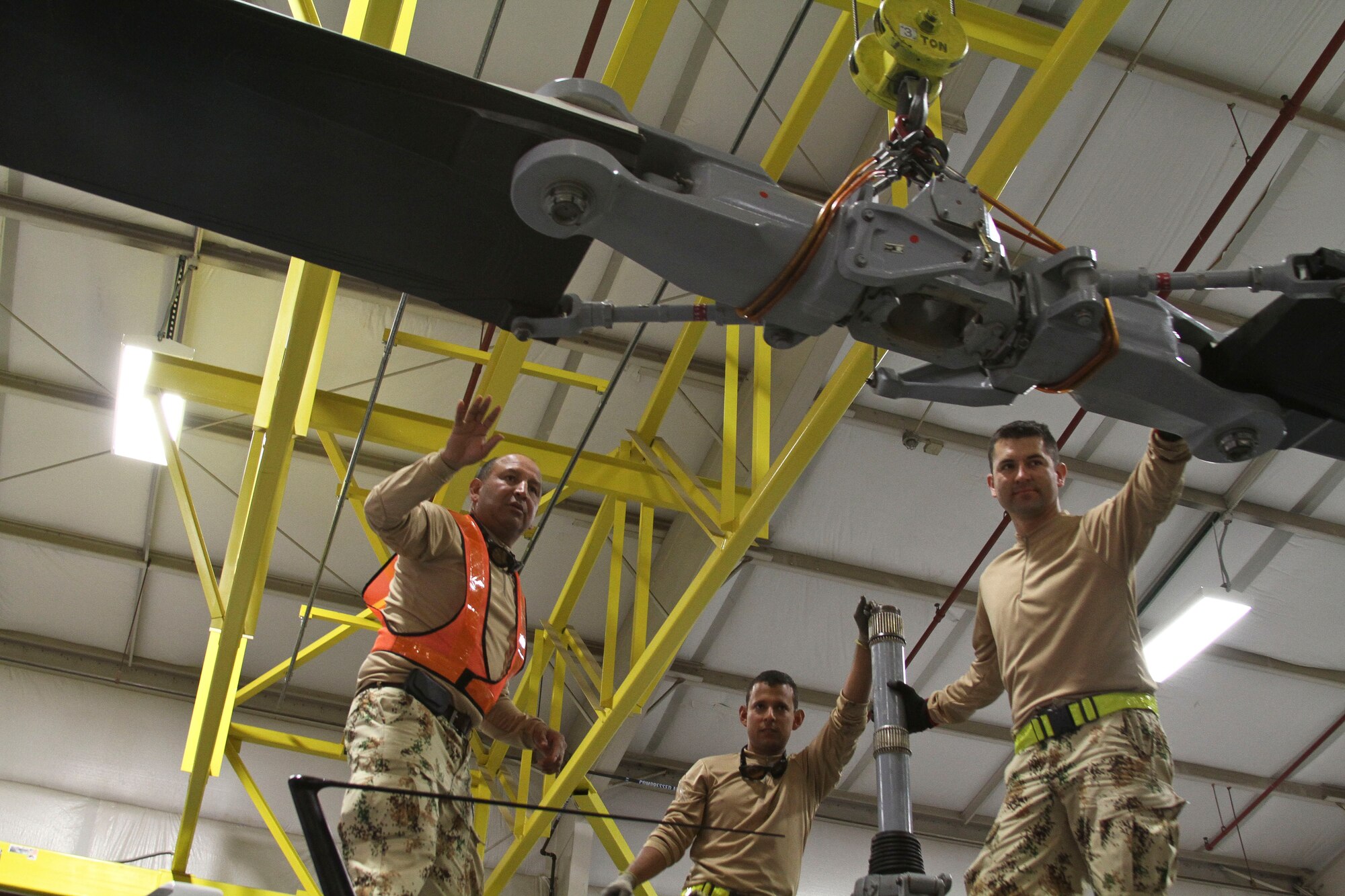 Maintainers from the Colombian Air Force use a hoist to move the main rotor blade for the Colombian Air Force Bell 212 helicopter in place on the aircraft in preparation for Exercise ANGEL THUNDER at Davis-Monthan AFB, Ariz., April 29, 2014.  Exercise ANGEL THUNDER is an annual exercise that supports the DoD's training requirements for personnel recovery, but also fosters relationships between joint, interagency, and coalition partners. This year's exercise will occur from May 4-17 throughout Arizona and off the coast of California.  The Colombian military is one of the largest international participants of this year’s Exercise ANGEL THUNDER. (U.S. Air Force photo by Staff Sgt. Heather R. Redman/Released)
