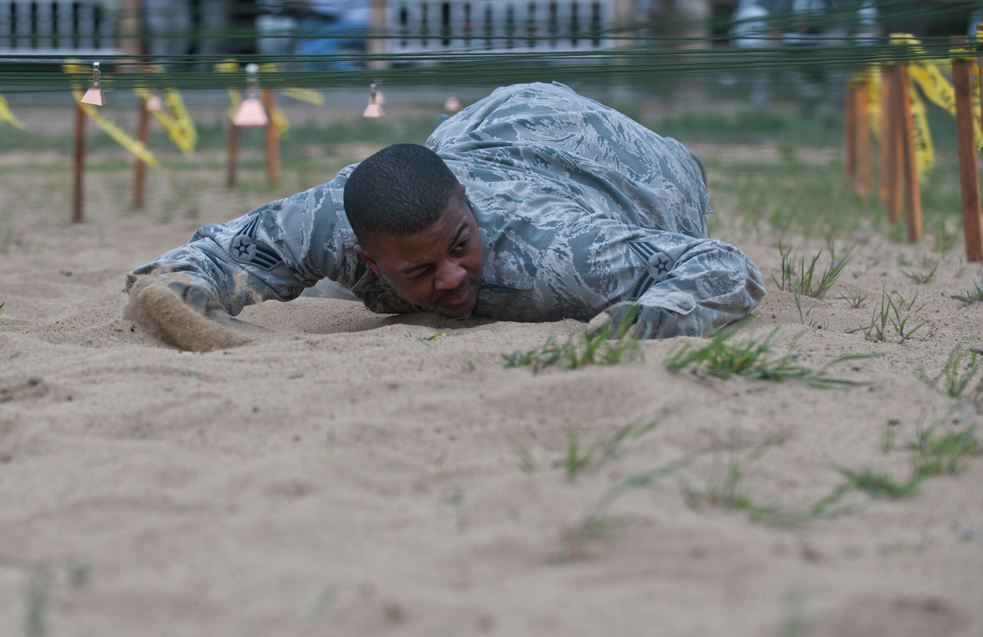 Senior Airman Jahvaun Alexander, 366th Security Forces Squadron staff armorer, low crawls through sand, April 22, 2014, at Mountain Home Air Force Base, Idaho. Alexander completed all 12 obstacles which tested each Airman mentally and physically. (U.S. Air Force Photo by Airman 1st Class Brittany A. Chase/Released)