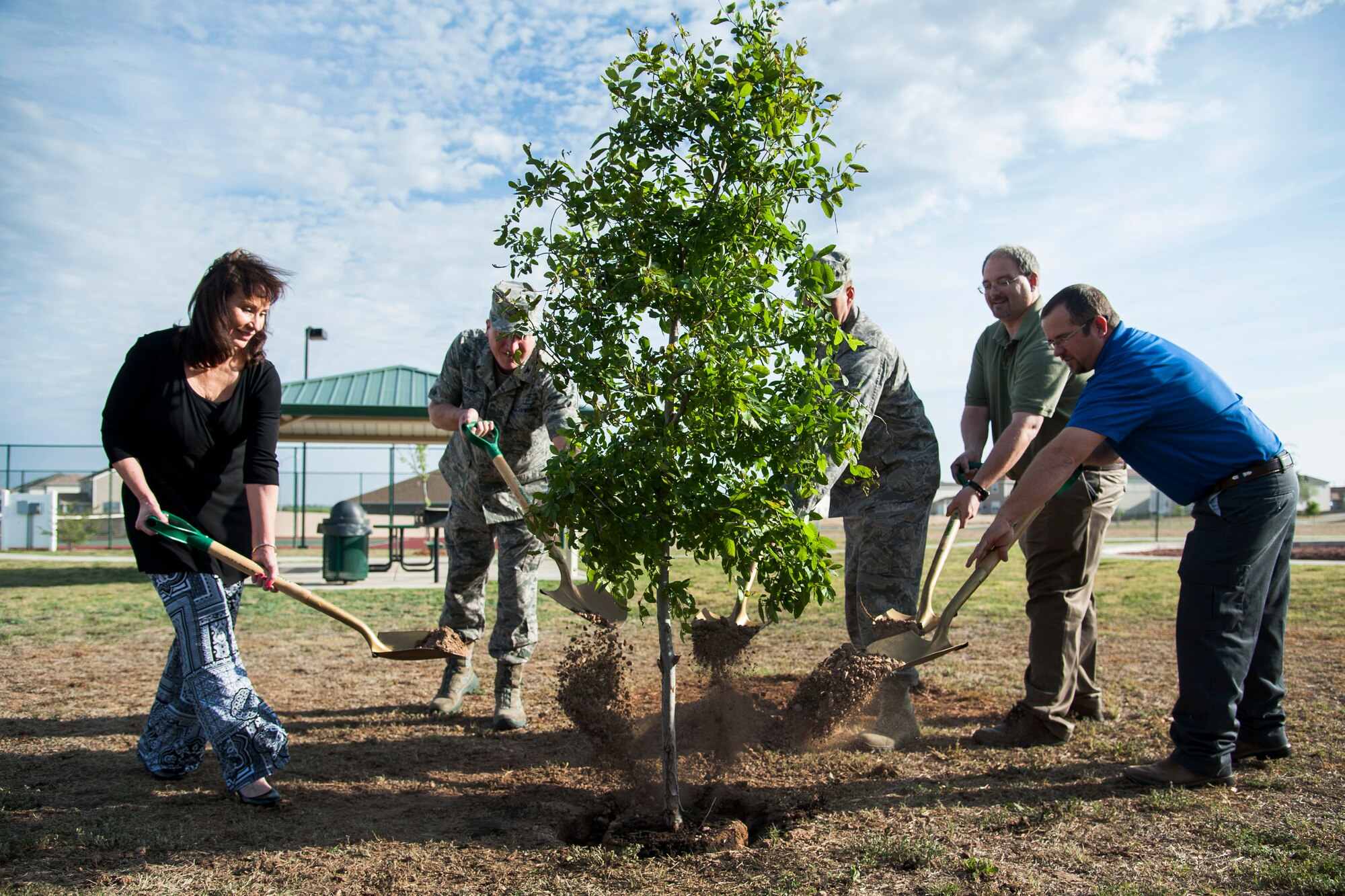 SAN ANGELO, Texas -- Members of the 17th Mission Support Group plant a cedar elm in off-base housing April 23. With the cedar elm being a native plant of the local area, it requires no extra water other than from rainfall. (U.S. Air Force photo/Senior Airman Michael Smith)