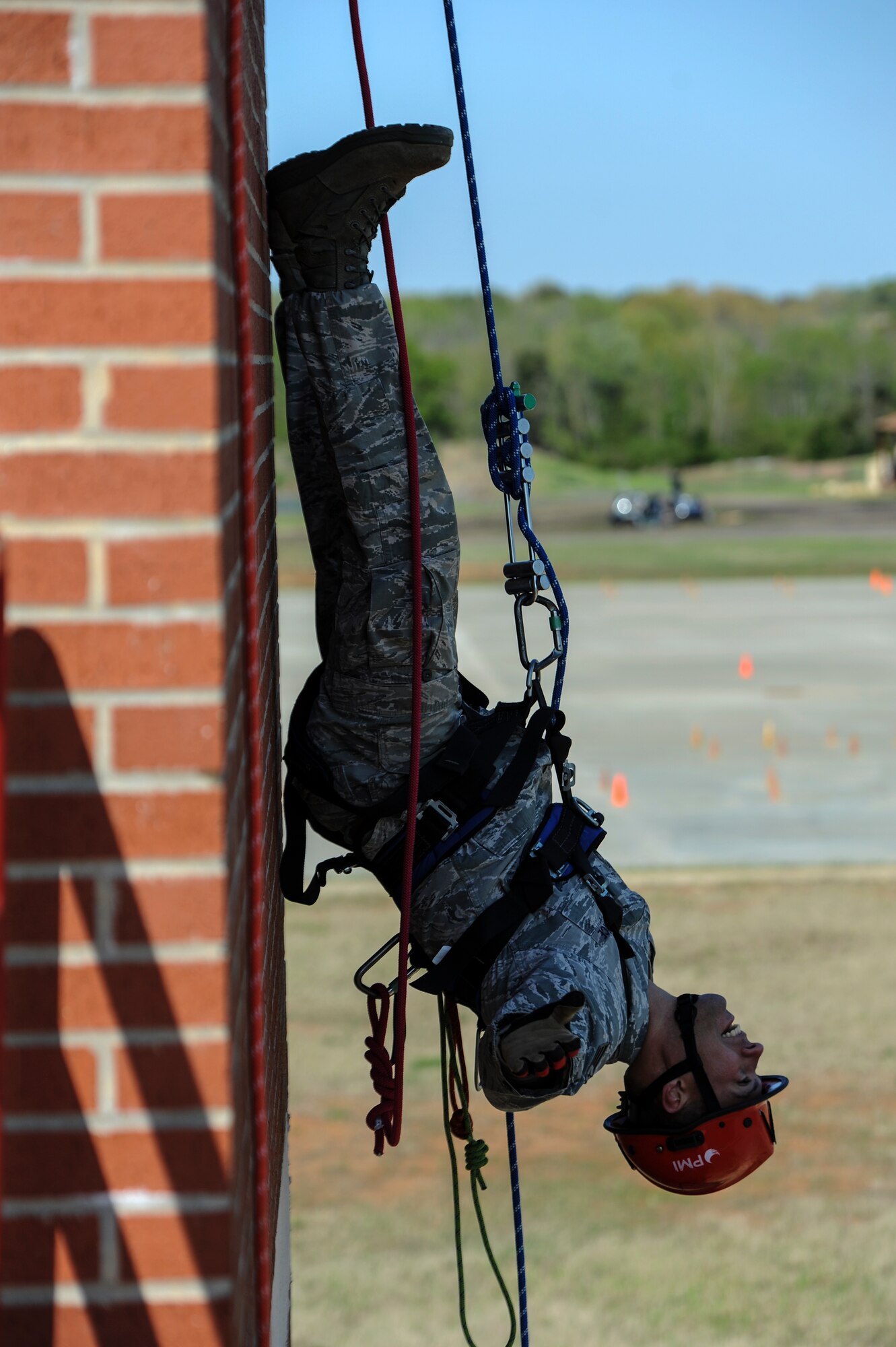 Senior Airman Justin Hanuschewics, a 19th Civil Engineer Squadron firefighter, hangs upside down from a burn building April 15, 2014, at the Jacksonville Fire Department, Jacksonville, Ark. During the Rescue Technician course, Team Little Rock firefighters were instructed to hang upside down after rappelling halfway down the building, then finish rappelling to the ground. (U.S. Air Force photo by Staff Sgt. Jessica Condit)