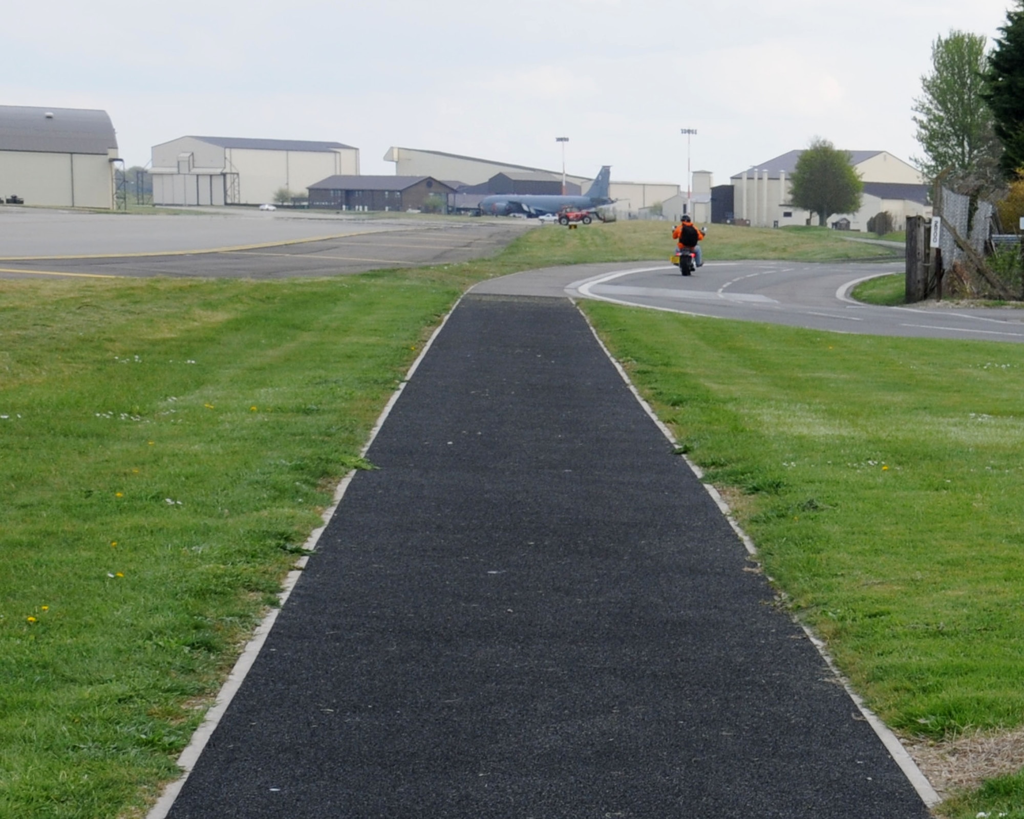 A running path is in the narrow space between the active taxiway and the road April 11, 2014, near South Perimeter Road by Taxiway Bravo on RAF Mildenhall, England. Runners must follow the same safety instructions issued to drivers – stop and look for aircraft and only proceed when the taxiway is completely clear. (U.S. Air Force photo by Gina Randall/Released)