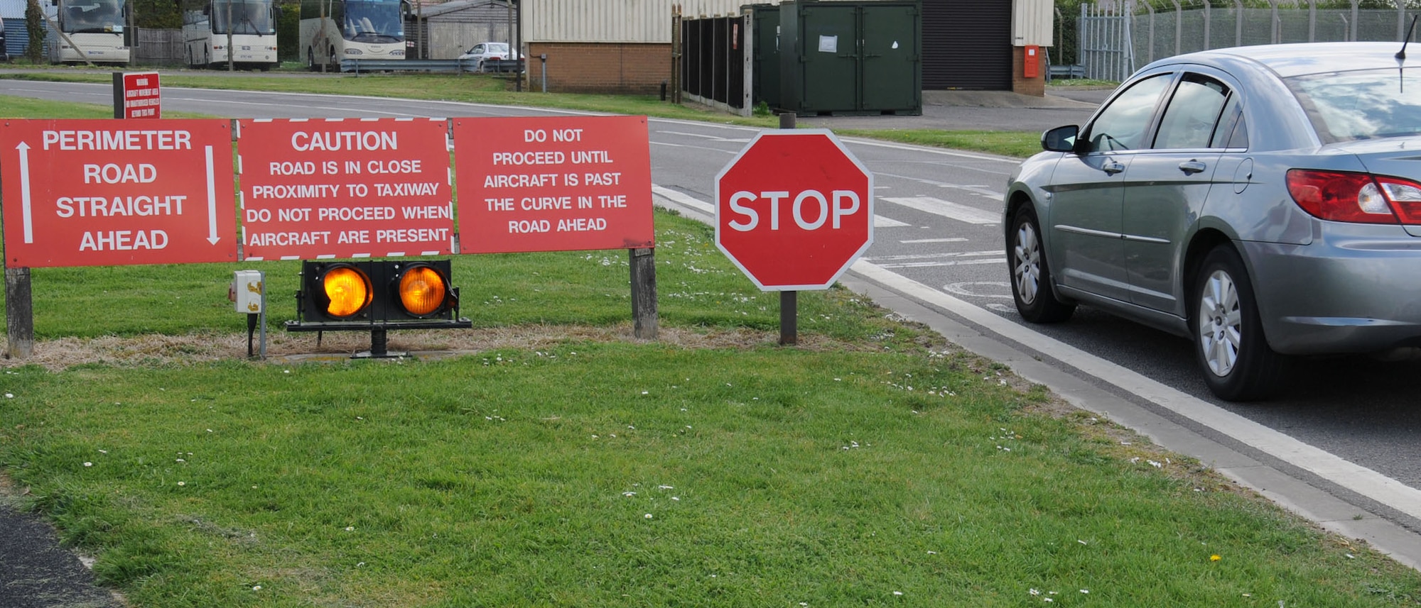 A Team Mildenhall member observes the stop sign and halts his or her vehicle April 11, 2014, on South Perimeter Road by Taxiway Bravo on RAF Mildenhall, England. Failing to stop could result in taxiing aircraft on the runway having to emergency brake for cars. Road users must always stop, look for aircraft and only when the taxiway is completely clear may they proceed with caution. (U.S. Air Force photo by Gina Randall/Released)